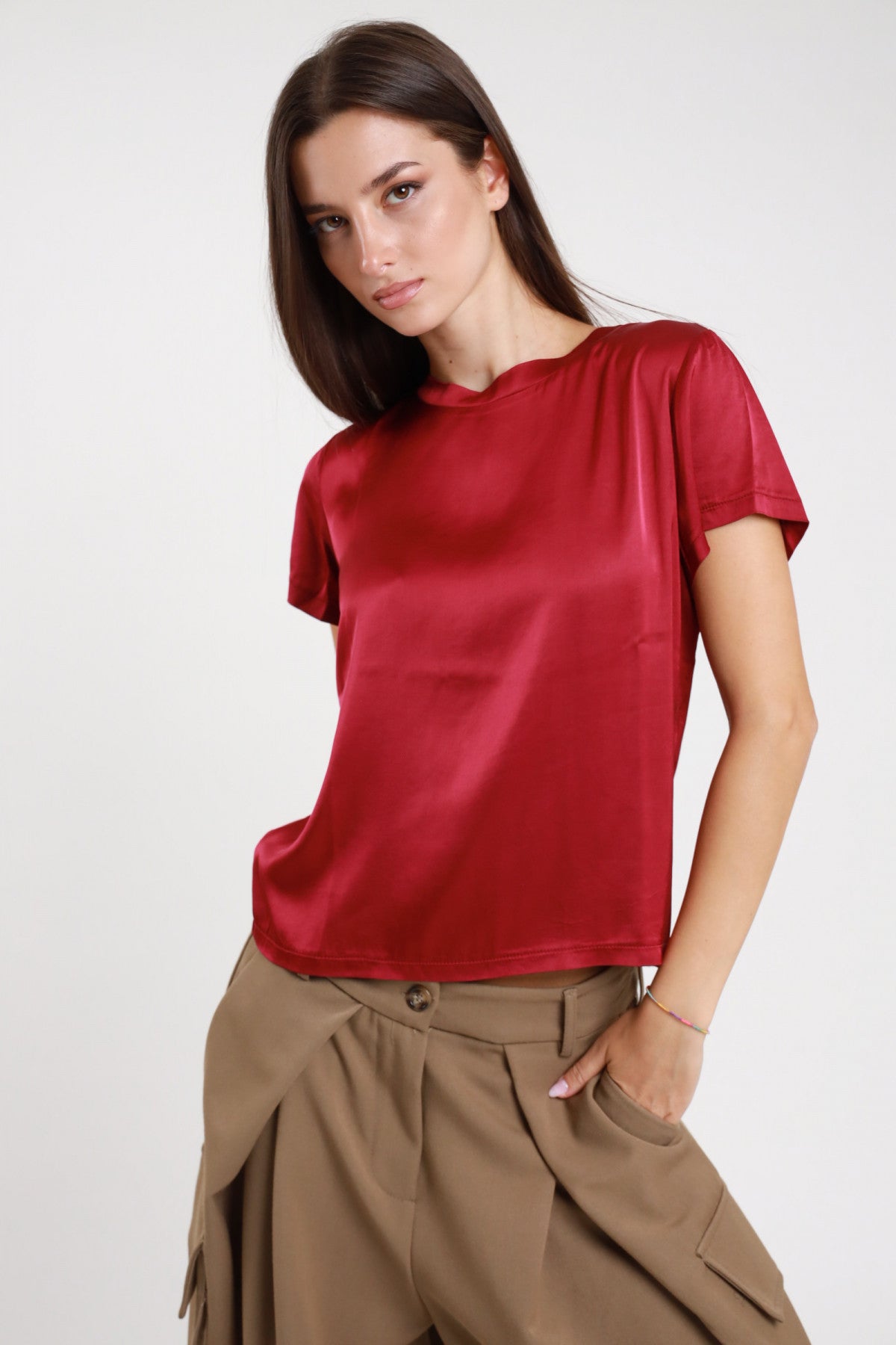 T-shirt stretch satinata rosso bordeaux con girocollo abbinata a pantaloni cammello