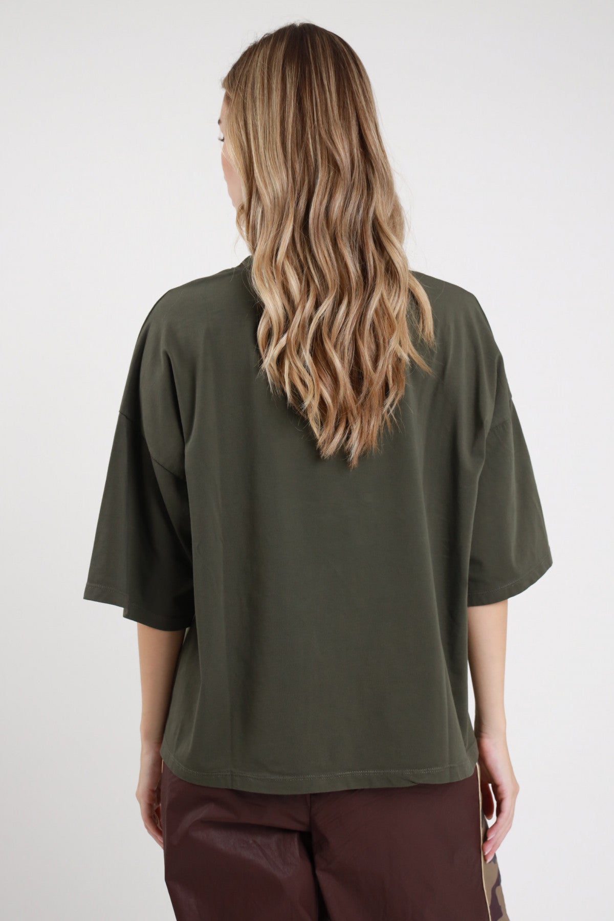 T-shirt Aquila verde militare oliva 95% cotone oversize boxy drop shoulder retro liscio posteriore intera - modella intera posteriore capelli biondi ondulati sfondo bianco pantalone bande cioccolato abbinato