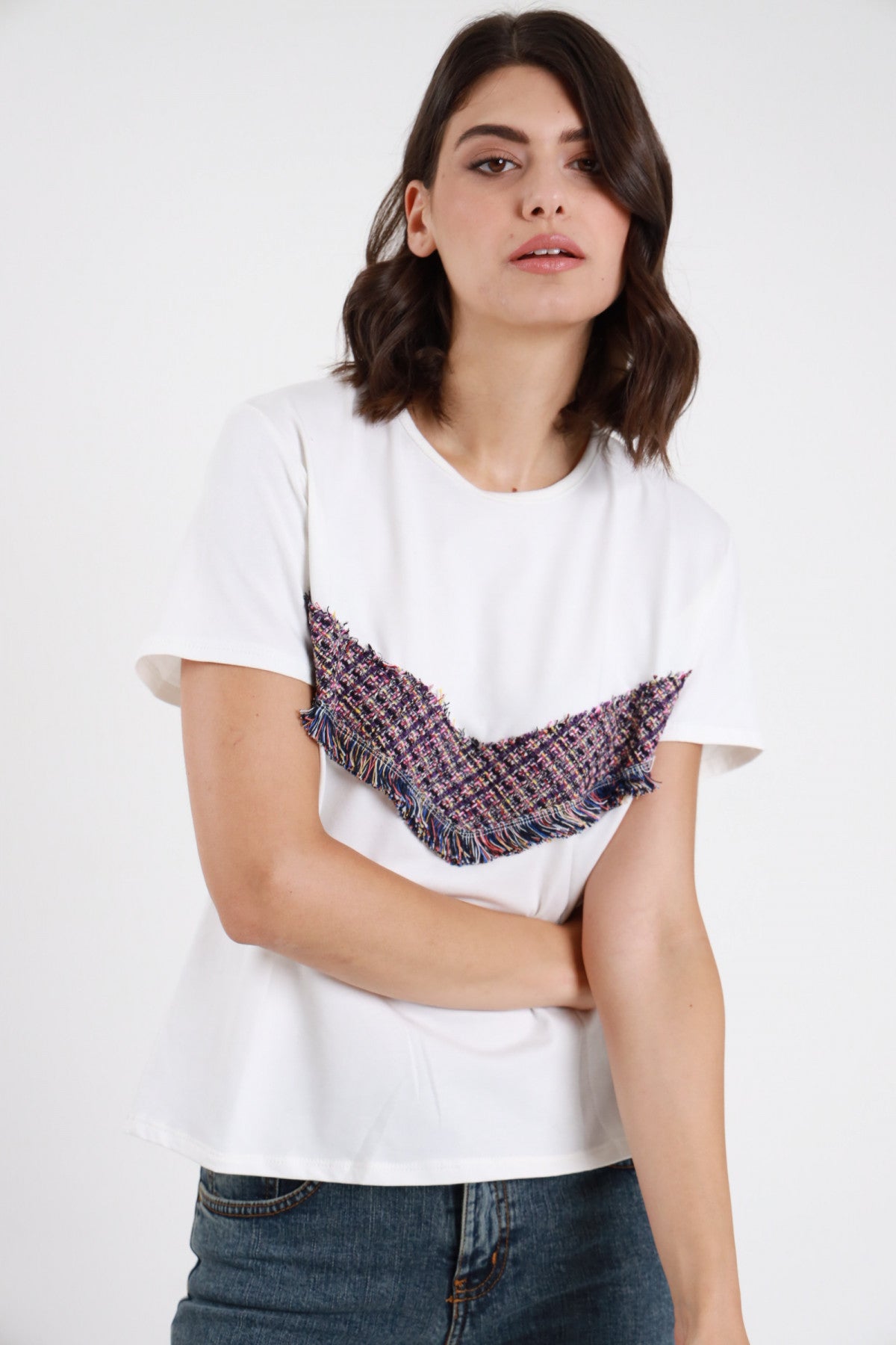 T-shirt tweed bianca donna boxy girocollo maniche corte banda tweed V rovesciata frange - vista frontale braccia conserte con jeans blu
