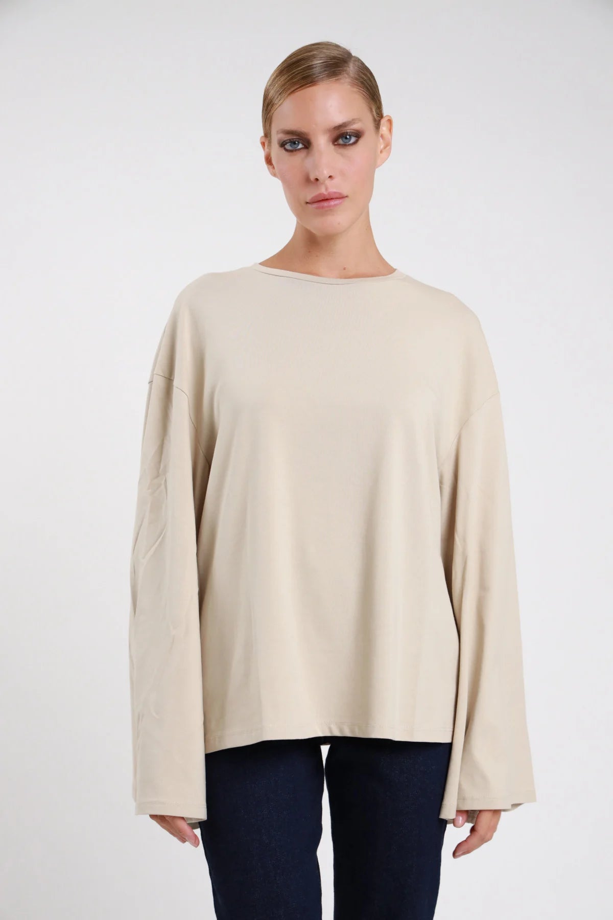 T-shirt manica campana Susy Mix beige chiaro con spalle scese, indossata con jeans