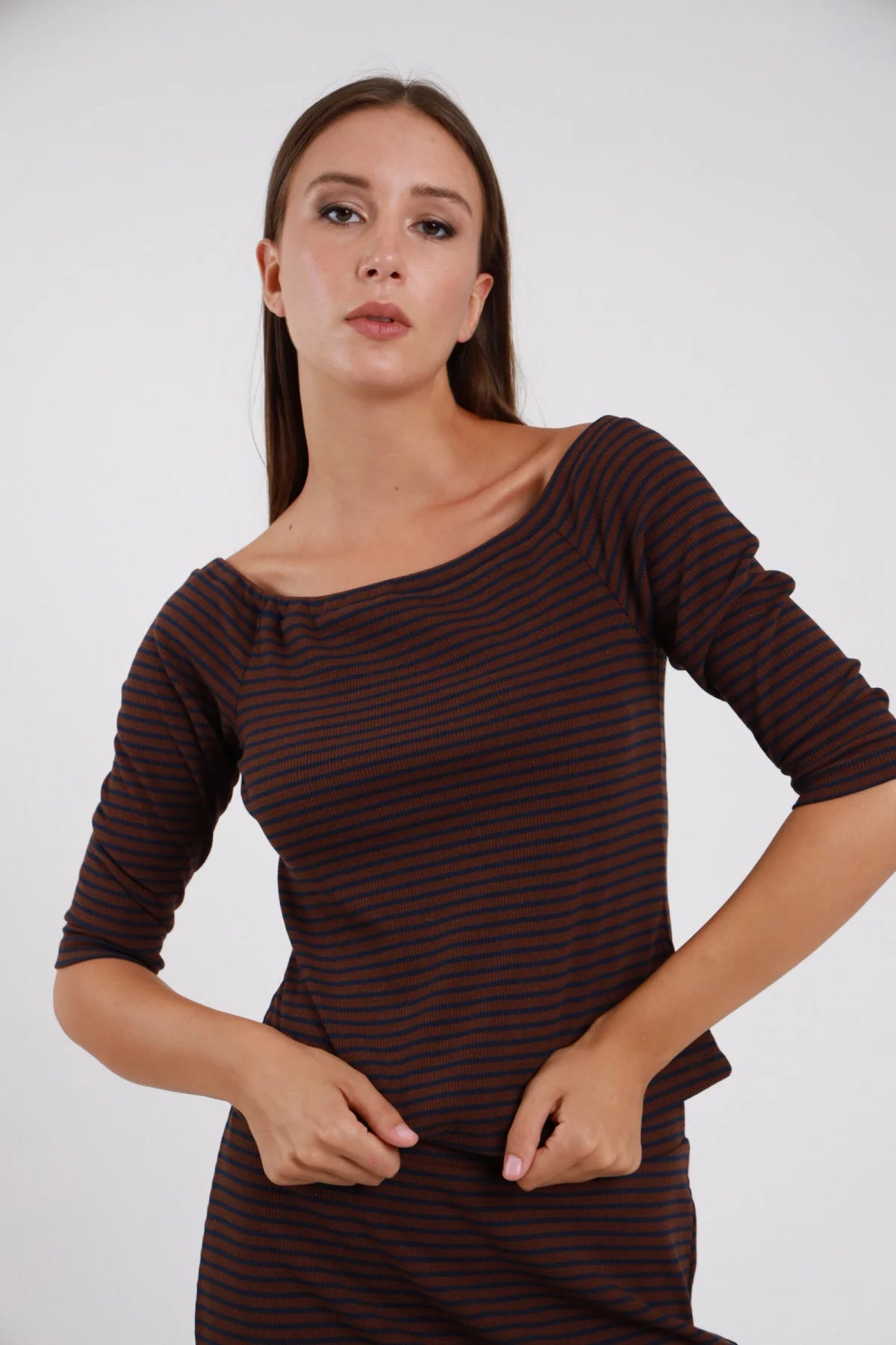 Top Righe Lurex marrone terracotta rosso blu scuro 48% cotone scollo barchetta ampio manica 3/4 silhouette crop semi-aderente - modella busto frontale posa mani intrecciate davanti sguardo frontale capelli castani lisci sfondo bianco gonna coordinata righe marrone terracotta