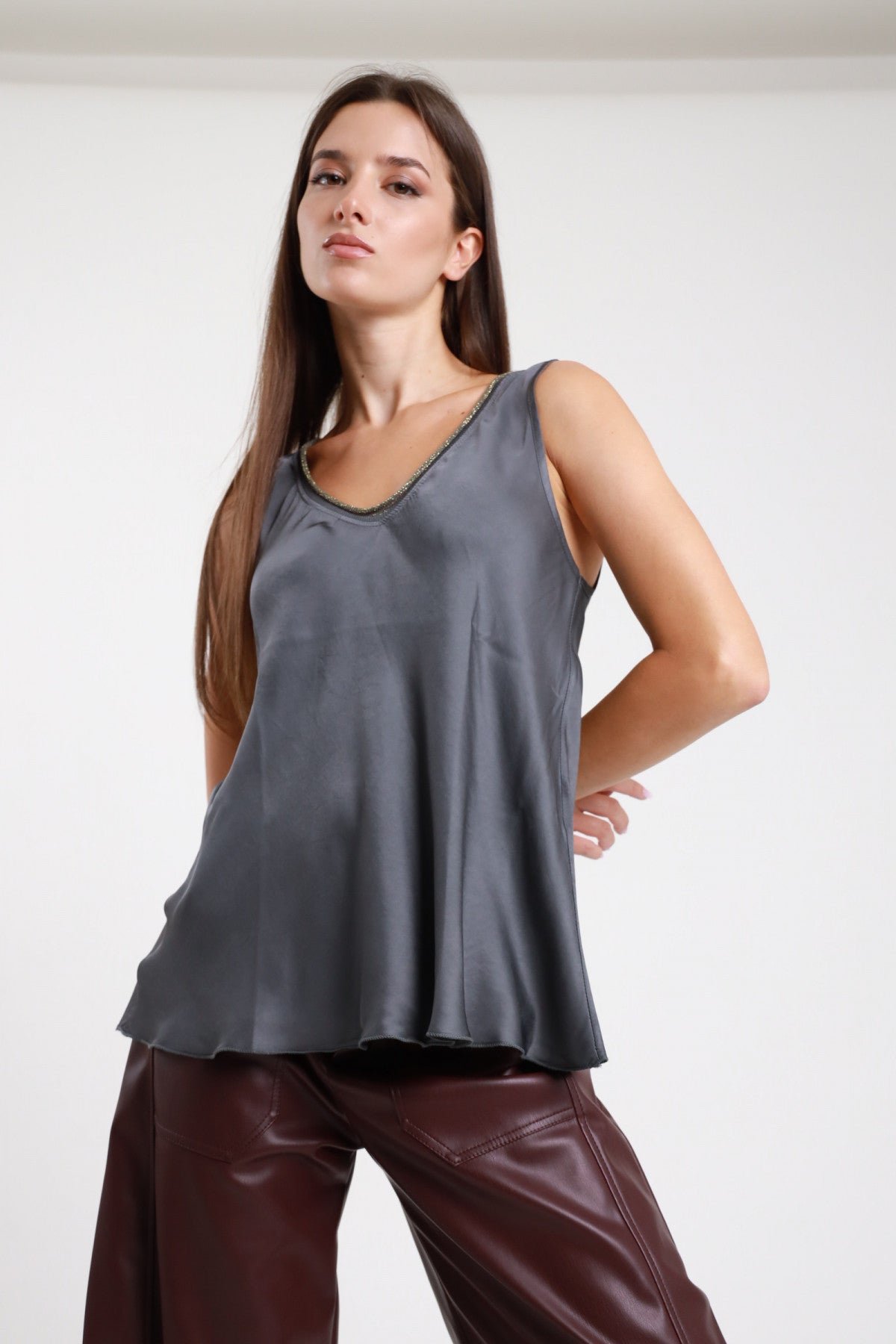Top scollo V grigio antracite donna Susy Mix – viscosa satinata bordo glitter vista frontale con pantaloni in pelle bordeaux