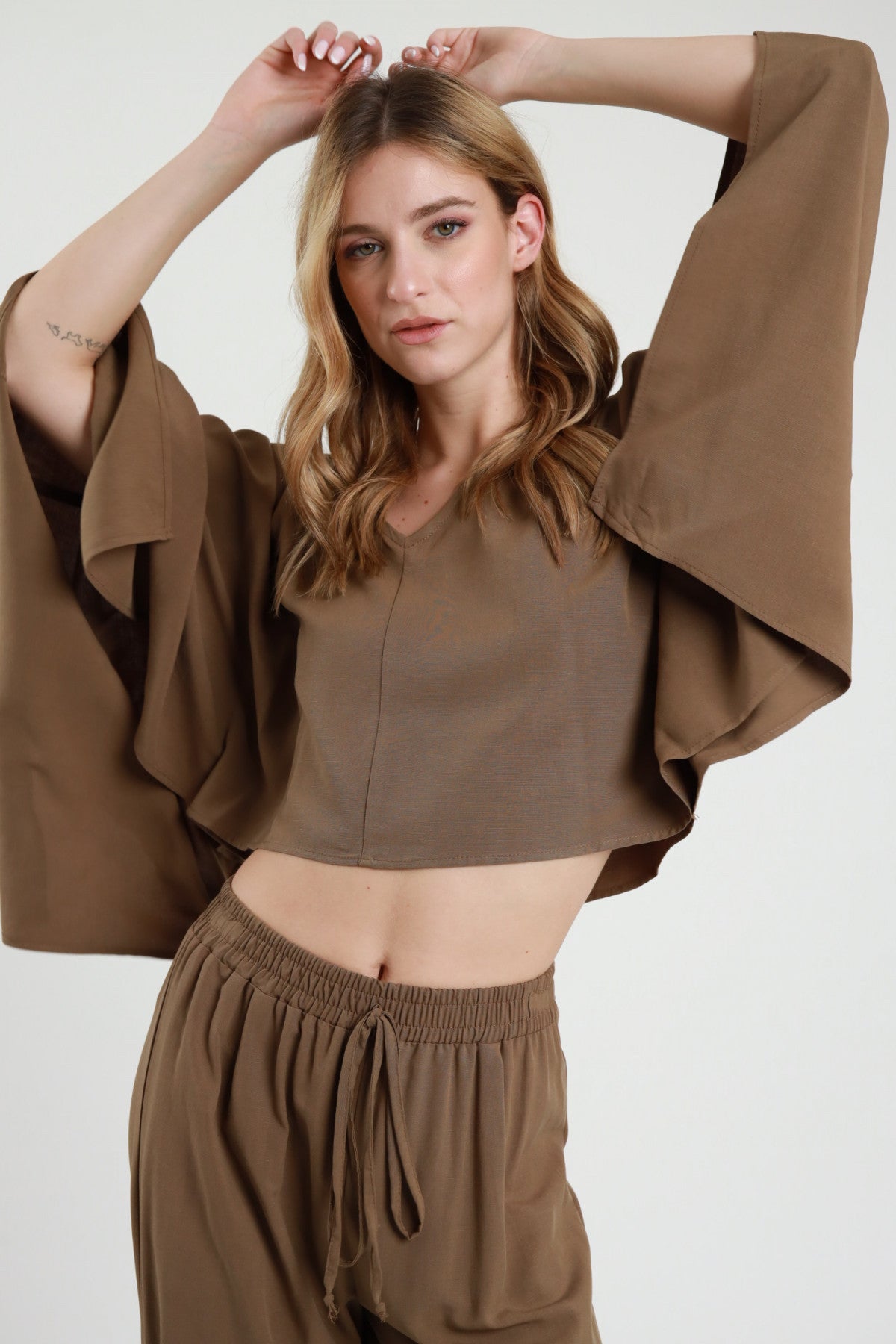 Crop top maniche kimono cammello Susy Mix – modella con braccia alzate