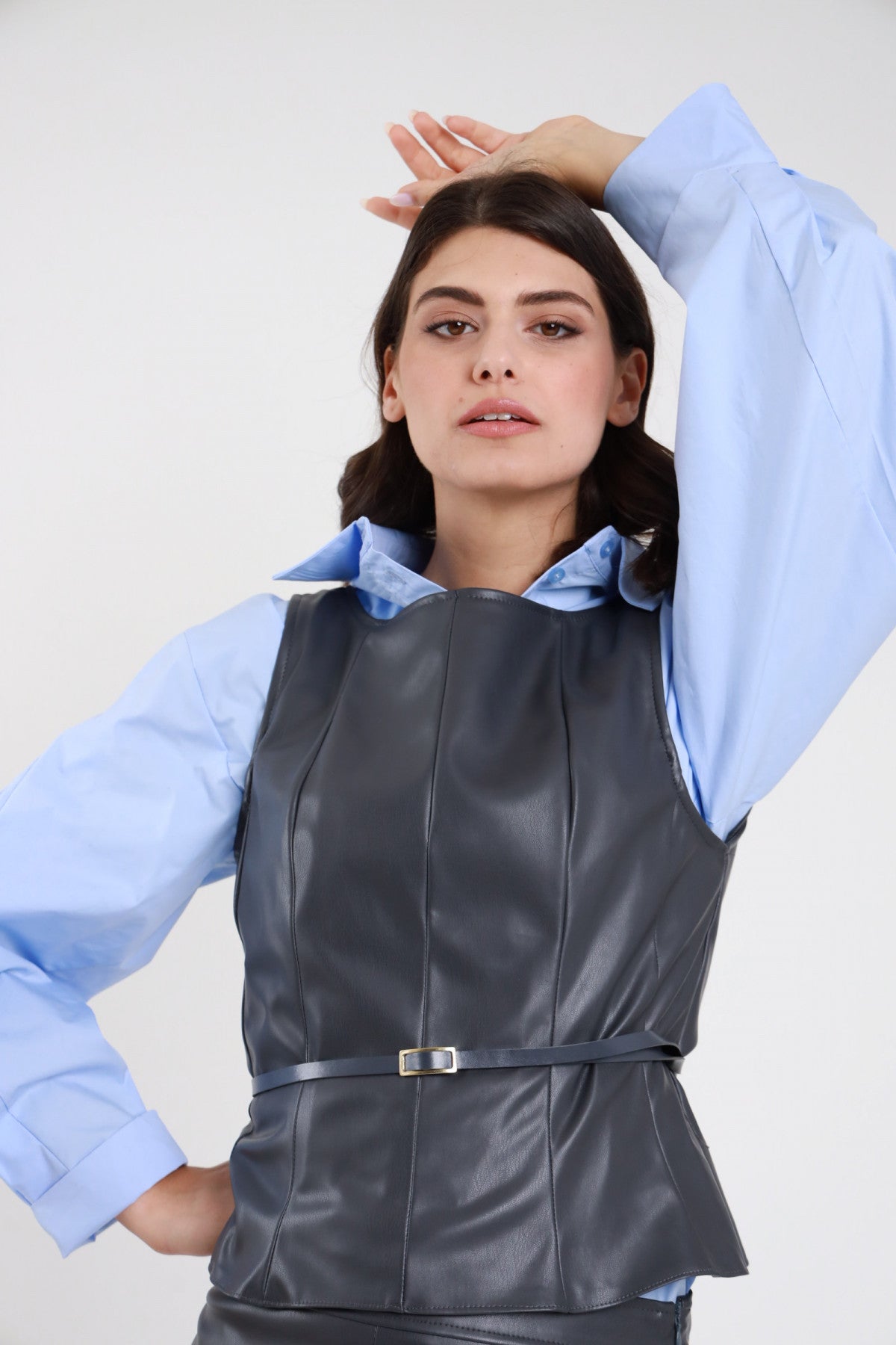 Top ecopelle grigio antracite donna Susy Mix – scollo barca peplum cintura fibbia vista frontale con camicia azzurra