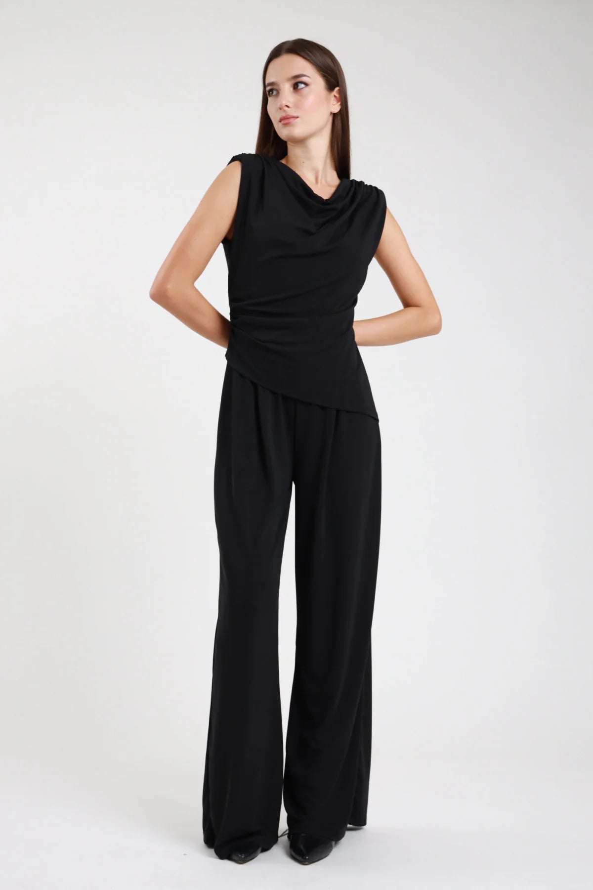 Tuta intera nera con top drappeggiato e pantalone palazzo - vista frontale modella